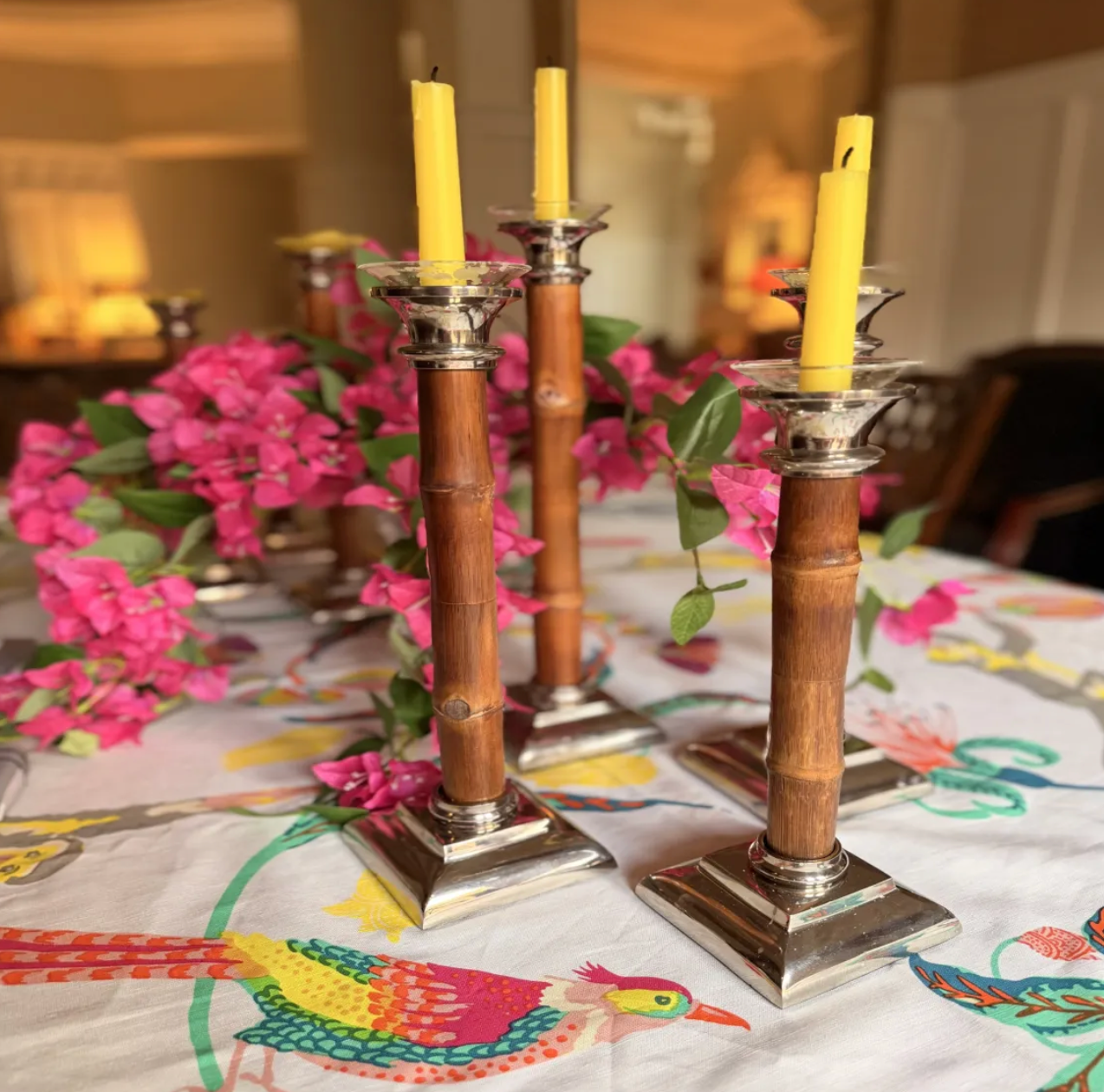 Wooden candlesticks with yellow candles and pink flowers