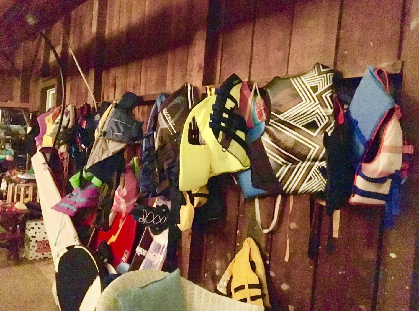 Colorful life jackets hanging on wooden wall