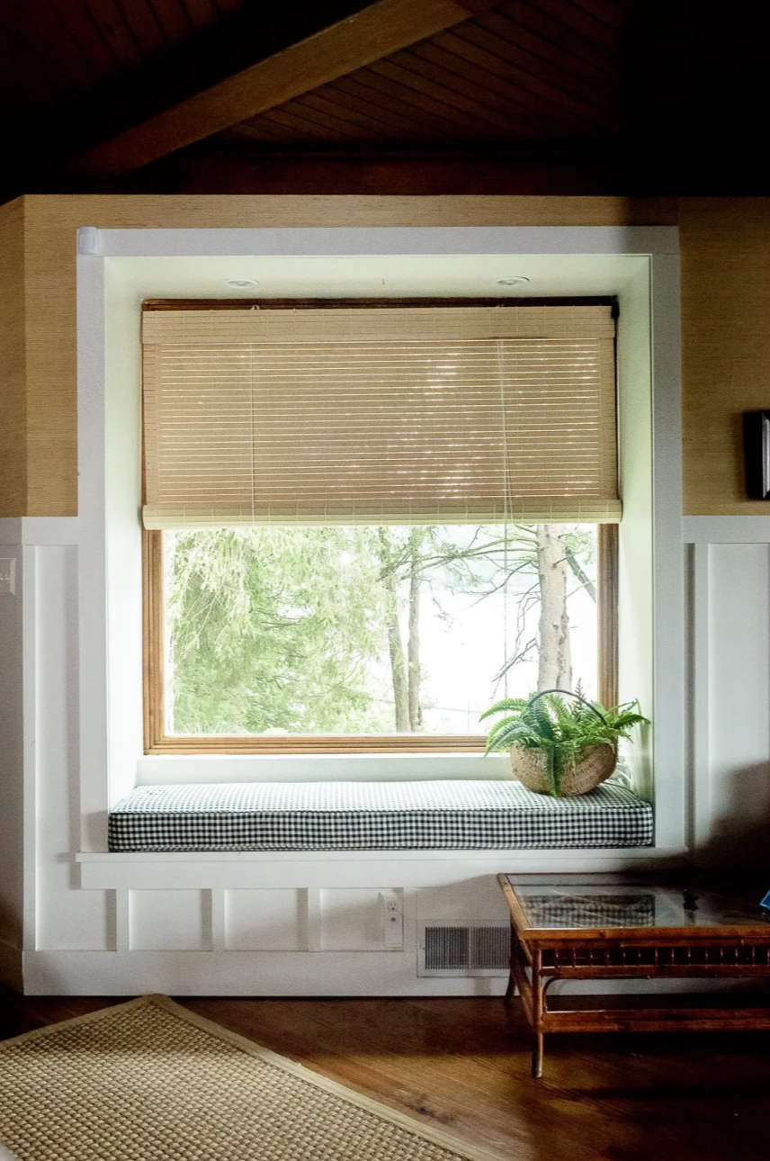 Window seat with roman shade and potted plant