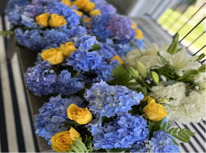 Blue hydrangeas and yellow roses floral arrangement